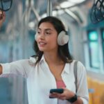 4k footage of Woman holding handrail and listening music in the subway